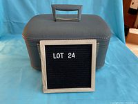 Front and side view of vintage blue makeup case with handle visible and matching gray latches