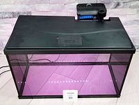 Front angled view of the 10 gallon black glass fish tank aquarium with lid and power filter attached showing length and depth.