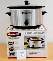 Bravetti stainless steel slow cooker on top of its box showing front and control knob.