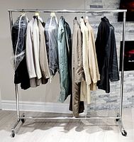 Full view of garment rack carrying various jackets and coats on hangers, showing the length and stability of the rack.