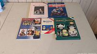Five pottery collectors books spread out on a table showing titles and covers with pottery images.