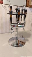 Full view of the bar tools carousel including several tools with bakelite handles and chrome stand