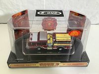 Close up photo of one Code 3 Boston fire truck model in original clear display packaging showing detailed die-cast fire engine with serial numbered base