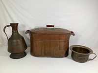 Photo showing all three items side by side on a plain backdrop: large copper pitcher, large copper wash tub with lid, brass train chamber pot.