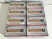 Top view of eight boxed Corgi American Fire Engine Classics 1:50 scale fire engine models stacked in two columns, showing brand and series logo on boxes.