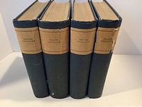 Front view of four volumes of English Literature with black covers and tan spine labels showing title.