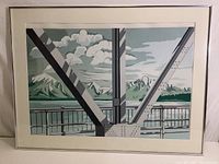 Full view of framed print showing bridge structure with mountains and clouds in background.
