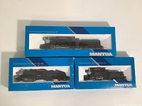 Three Mantua HO scale model locomotives in original blue boxes with clear display windows, showing Pacific Camelback Reading, Switcher NYC, and Big Six New York Central models.