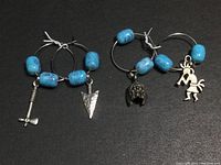 Close up of silver hoop earrings with blue glass beads and Native American charms showing details of design