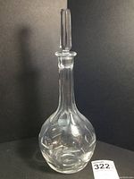 Full view of Orrefors crystal decanter with stopper against black background.
