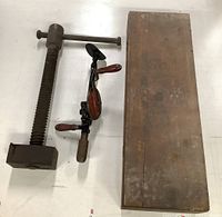 Photo showing the wooden box along with the hand drill and vice clamp laid side by side on a white surface.
