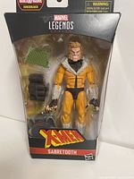 Front view of packaged Marvel Legends Series X-Men Sabretooth action figure with accessories visible.