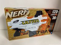 Front view of the boxed Nerf Ultra Amp blaster with a 6-dart clip showing brand and product details.