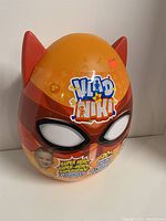 Front view of Vlad & Niki Superhero Surprise Egg in orange and red with mask design and Vlad & Niki logo