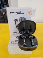 Photo showing both the earbuds and their charging cases with packaging visible.