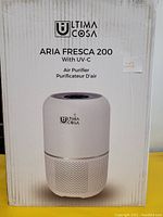 Front of the boxed Ultima Cosa Aria Fresca 200 air purifier showing product image, brand logo, and name.