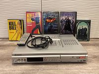 Pioneer DVD player with remote control and 5 DVDs (Kill Bill Vol 1 & 2, Batman The Dark Knight, The Matrix, The Patriot) arranged behind the player.