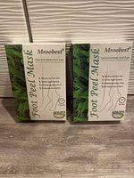 Two boxes of factory sealed Mroobest Foot Peel Mask for natural exfoliation of feet, moisturizing and callus peeling, 8 pairs total.