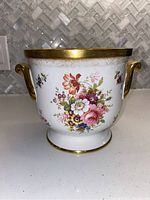 Front view of the floral bone china ice bucket with gold trim and handles
