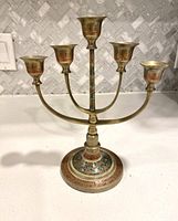 Full frontal shot of the 5-branch brass menorah showing candle holders and base.