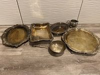 Full lot display of silver plated trays and bowls along with stainless steel milk pourer