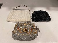 Set of three vintage beaded handbags: white, black, and grey with decorative beadwork