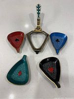 Top down view of five small brass cups with card suits symbols, one with handle.