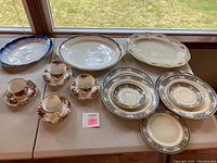 Full assortment of china including cups, saucers, plates, and platters with varied patterns and floral designs.