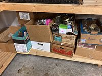 Canning jars and boxes stored on wooden shelves showing jars with metal rings and lids, assorted boxes including vintage boxes and modern packaging.