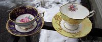 Pair of two different porcelain teacup and saucer sets placed side by side outdoors in winter setting