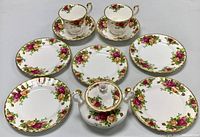 Full set with two cups, saucers, six plates and sugar bowl arranged for size comparison and detail.