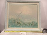 Front view of framed painting showing overall appearance with measuring tape indicating width of frame.