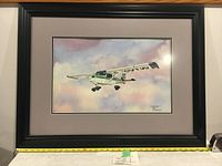 Full image of original watercolor painting of airplane by P J Snider in black wood frame with glass and grey mat, showing colors and frame.