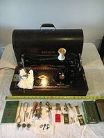 Full view of the SINGER vintage electrical sewing machine with multiple accessories displayed in front, including a manual, bobbins, and tools.