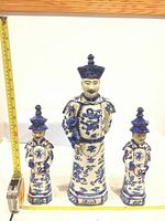 Front view of all three statues with measuring tape at left and bottom