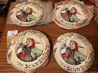 Four stacks of plates showing jester illustration and decorative border