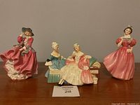 Three porcelain figurines displayed side by side