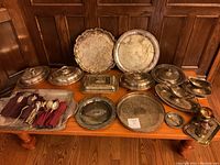 Full overview of the lot on wooden table showing all trays, covered dishes, gravy boats, cutlery, and pitcher