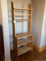 Front view of the tall pine bookshelf showing its five shelves made of natural pine wood with visible grain and knots.
