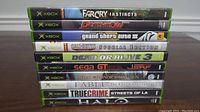 Stacked Xbox game cases showing spine labels of 10 games.