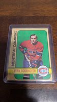 Front side of the 1972-73 Yvan Cournoyer hockey card showing player photo with Montreal Canadiens logo and green background.