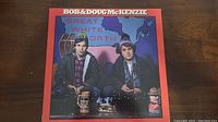 Front cover of the Bob & Doug McKenzie Great White North vinyl record showing two men in cold weather clothing sitting with Canadian themed background and mugs.