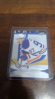 Front of Connor McDavid rookie hockey card showing action image in Oilers jersey, protected in plastic case.