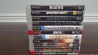 Stack of eleven PS3 game cases showing titles and rating labels.