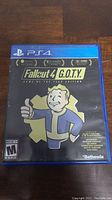 Closed case showing front cover of Fallout 4 G.O.T.Y. Edition for PS4 with Vault Boy artwork.