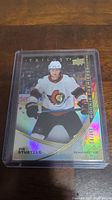 Front view of Tim Stuetzle rookie hockey card in clear protective case showing player image and text details.