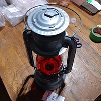 Top view of the GSW Beacon oil lantern showing the red glass globe and metal top with handle.