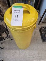 Top view of yellow painted metal cream can with lid and handle.