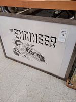 Framed ink engraving with stylized title 'The Engineer' and mechanical imagery, view of overall print and frame.
