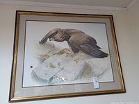 Framed print of an eagle perched on a rock, signed by Glen Loats.